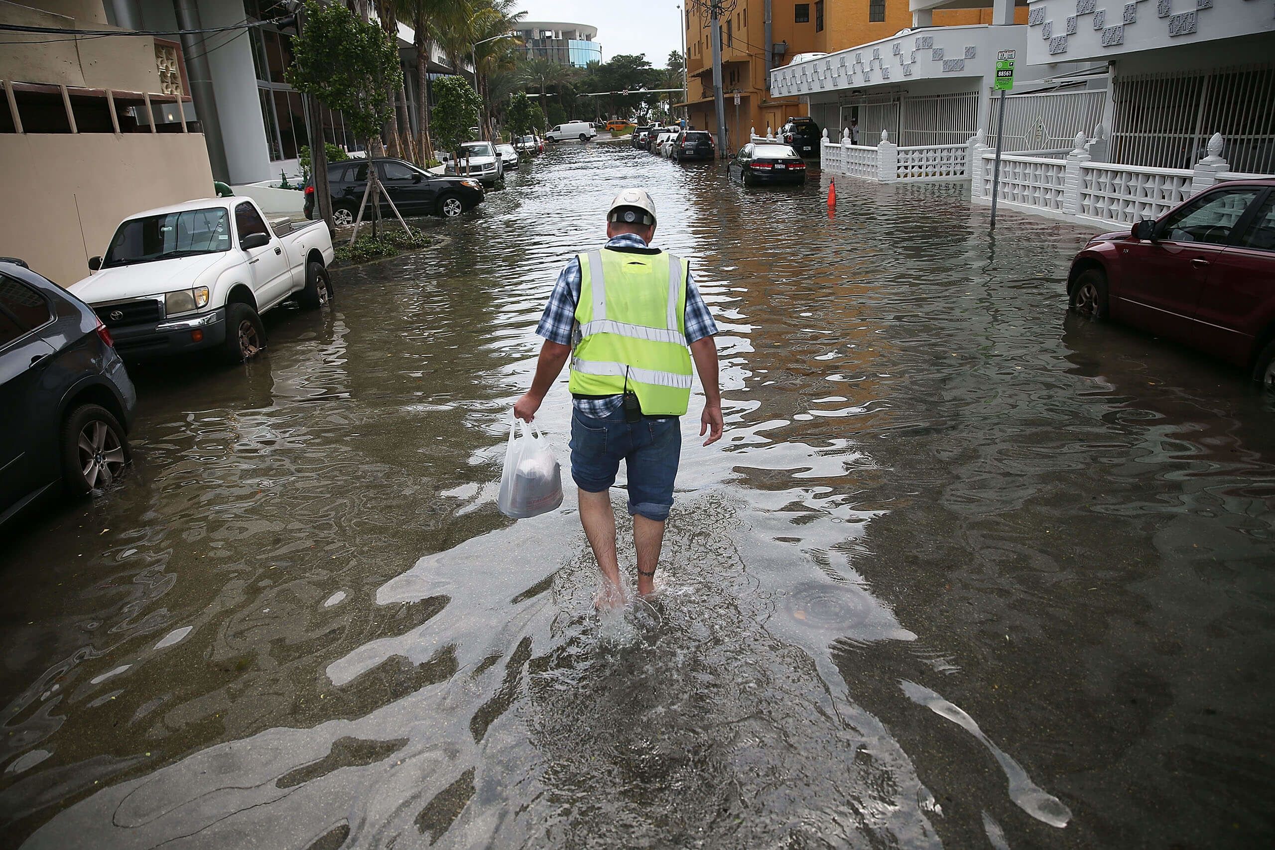 Howard Rogers walks through a flooded street during the King Tides of September 2015.